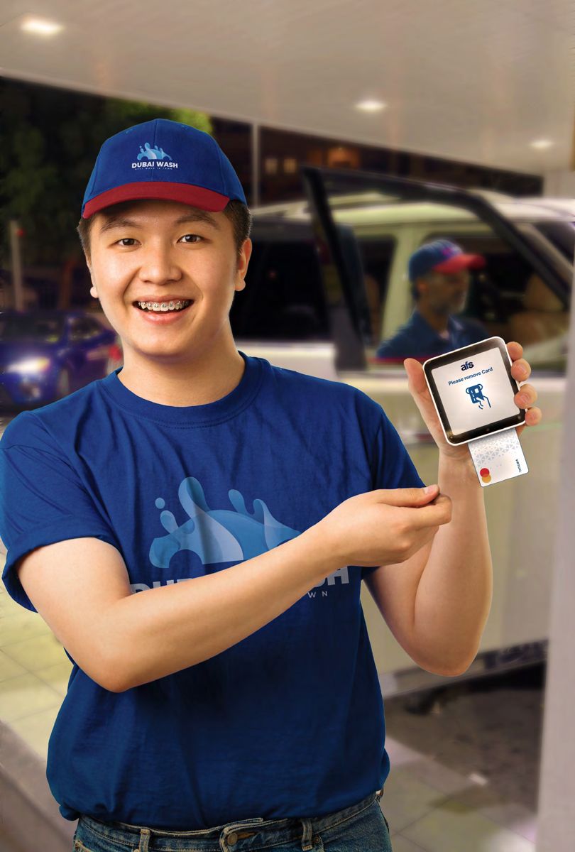 Attendant holding an AFS Lite Mini POS with a payment card
