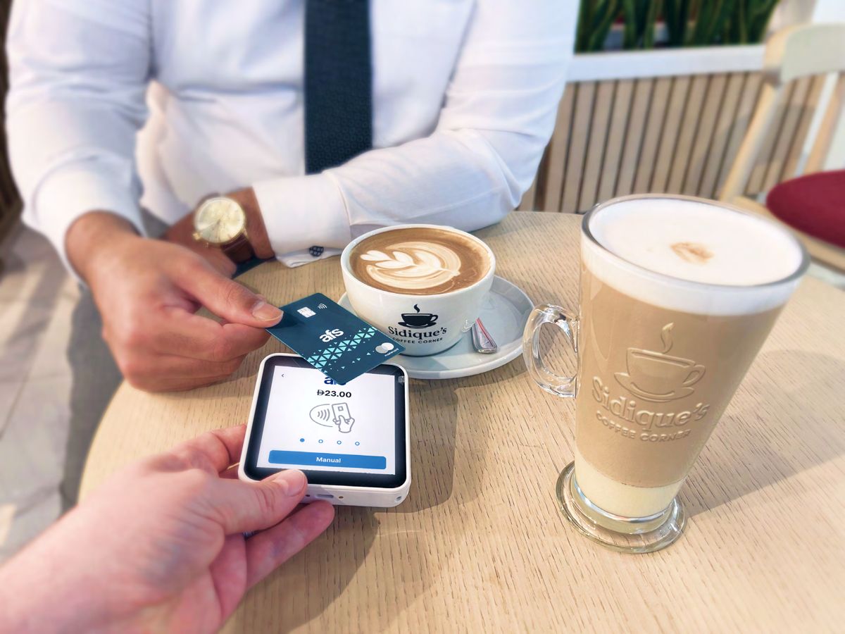 Customer tapping to pay at a coffee shop table on an AFS Lite Mini POS