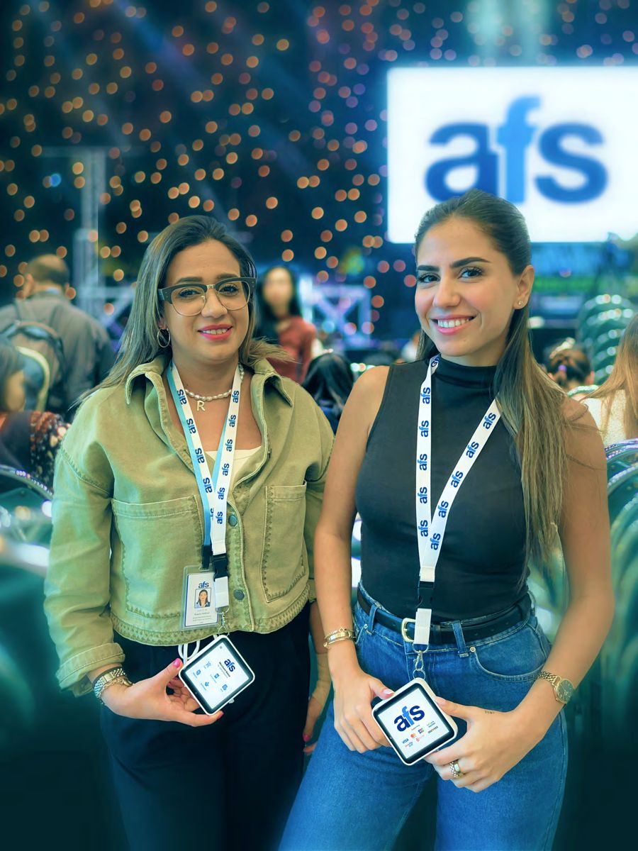 Team members wearing AFS Lite Mini POS devices on lanyards at an event