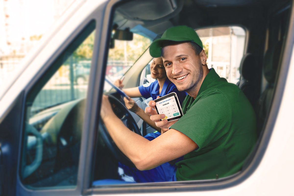 Field service team taking a payment on an AFS Lite Mini POS from a van
