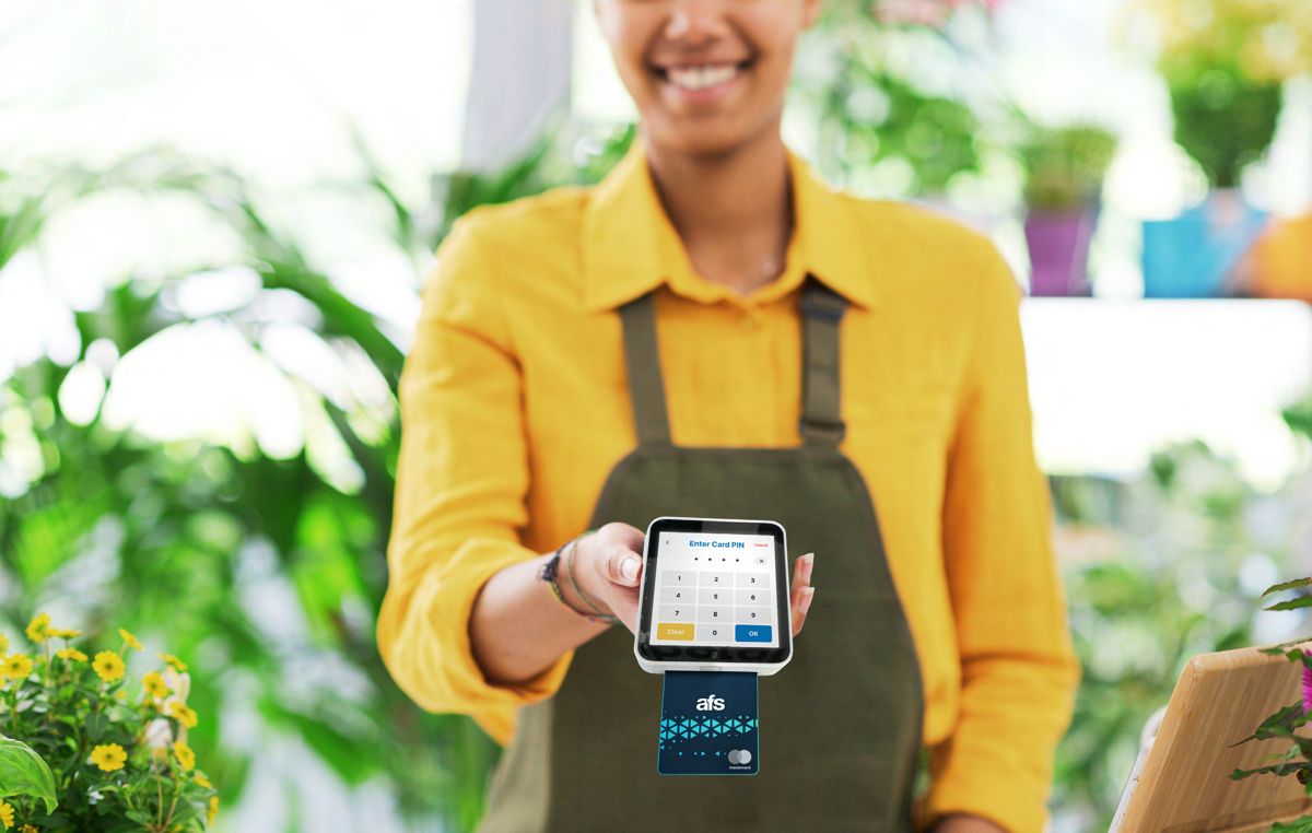 Merchant holding out an AFS Lite Mini POS for a chip and PIN payment