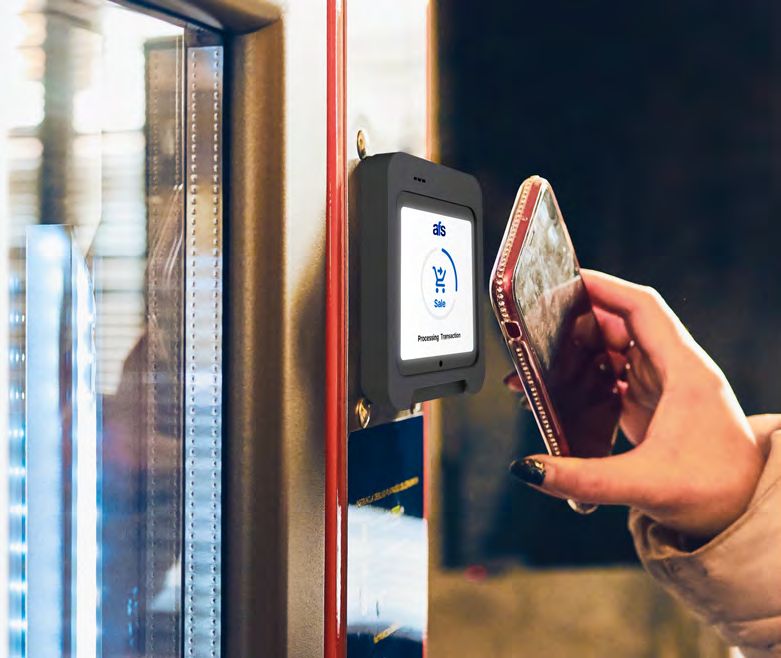 Customer tapping a phone on an AFS Lite Mini POS mounted in a vending machine
